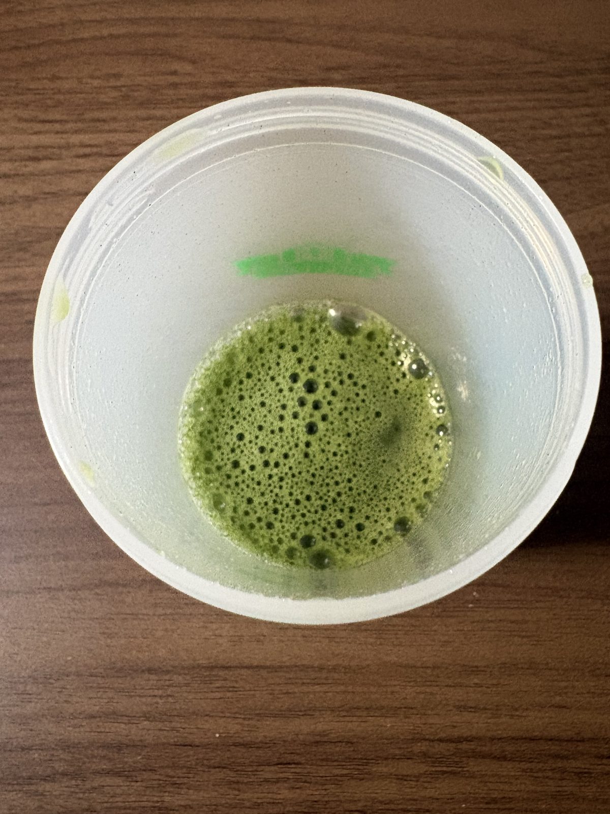 シェイカーで水に溶かした青汁。濃い緑色をしている