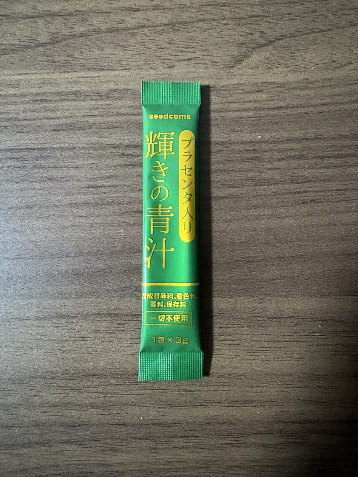 輝きの青汁のスティック1本。緑色のパッケージ