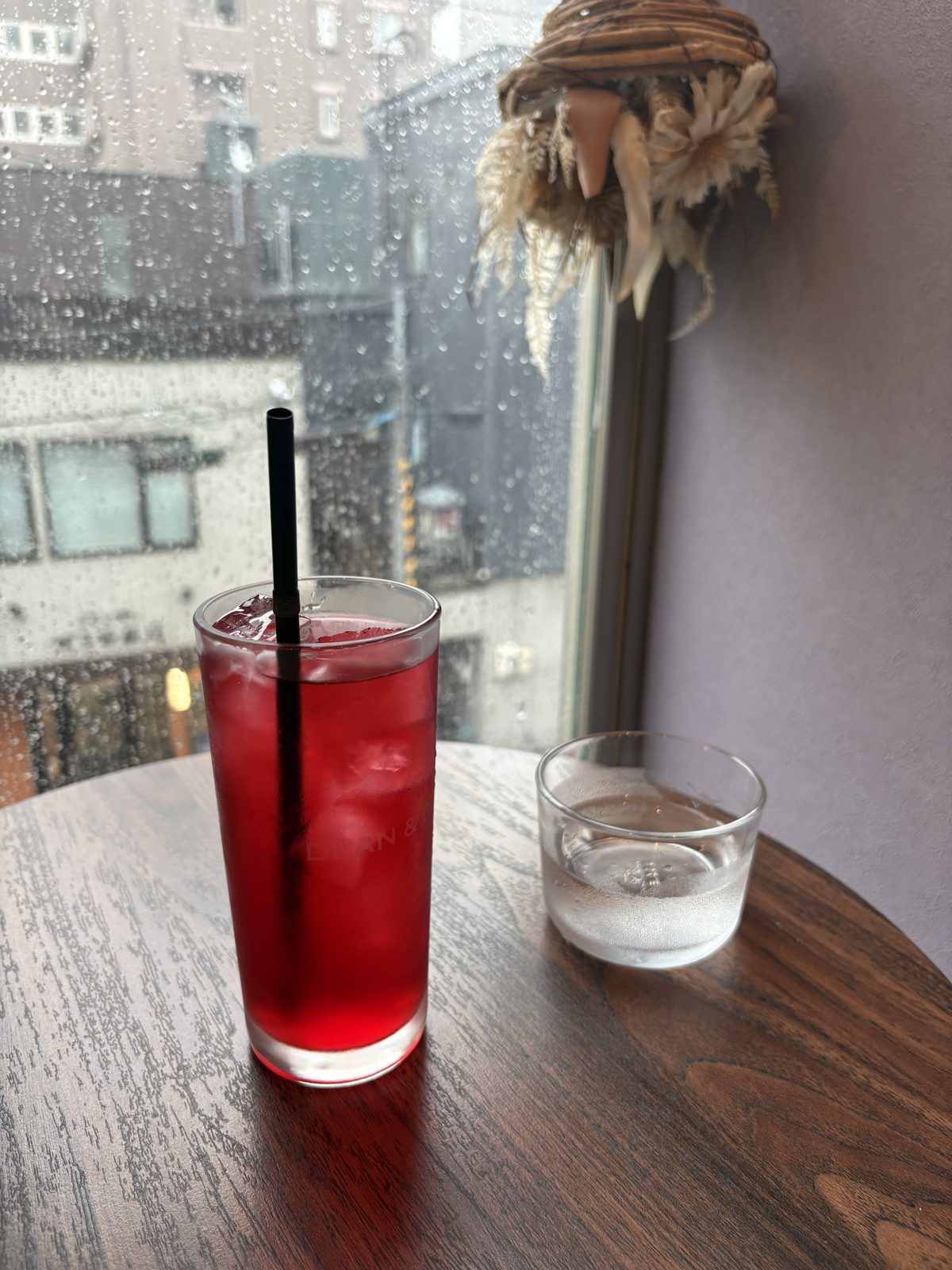 CAFUNE'のアイスハーブティー、ローズヒップバーベナ。窓際で赤いお茶が輝く