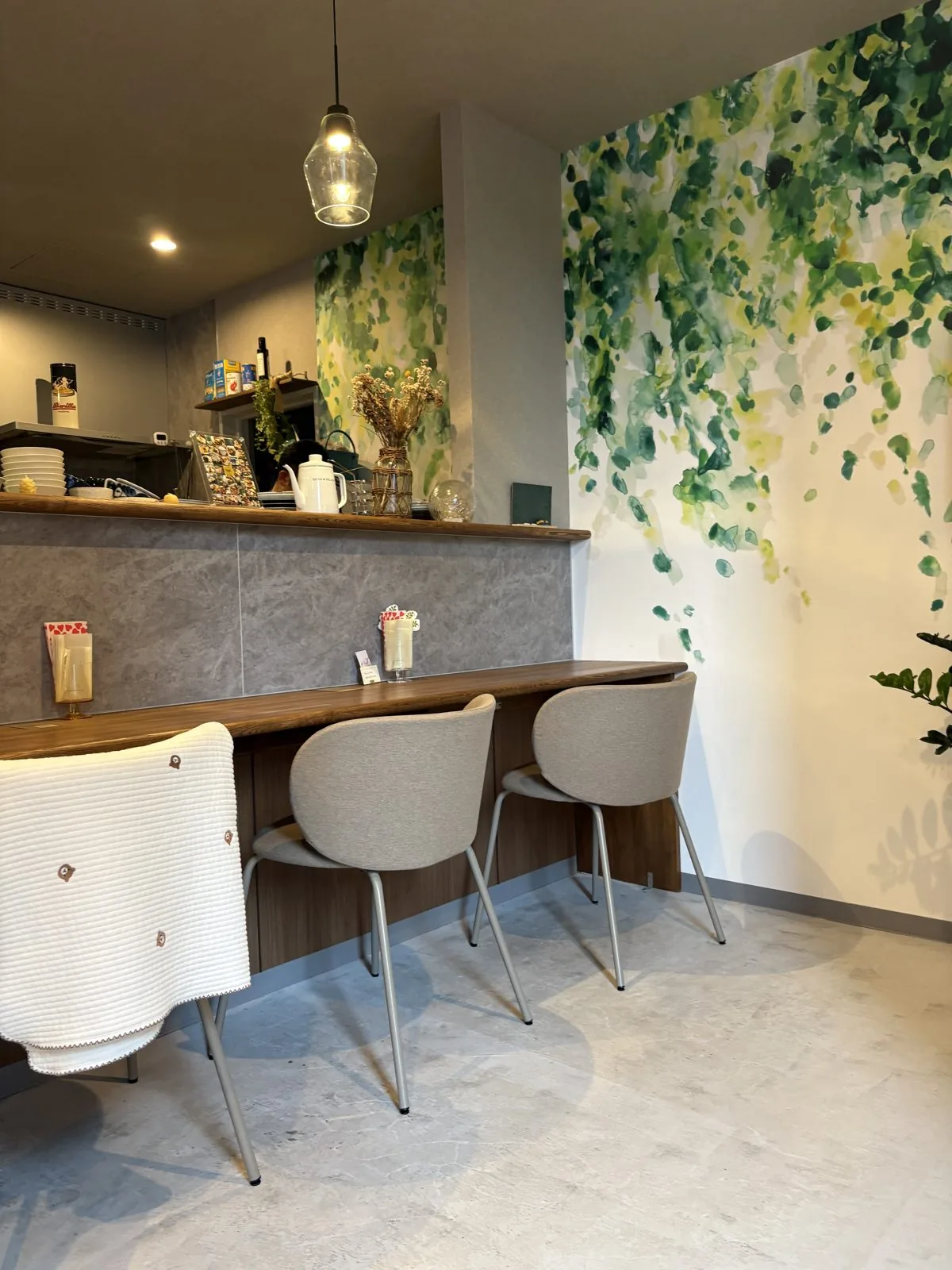 CAFUNE'の店内。ボタニカルアートの壁とカウンター席