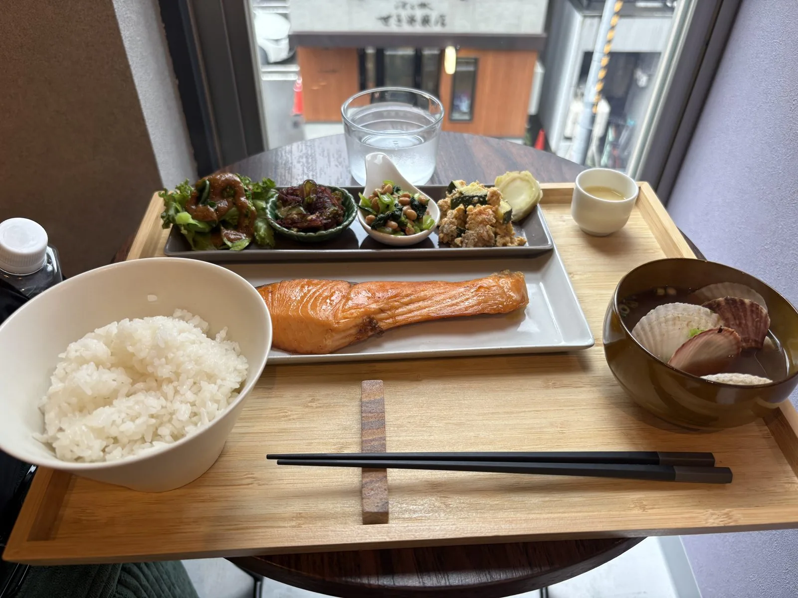 窓際の席に置かれたCAFUNE'の日替わり定食。窓の外に円山裏参道の街並み