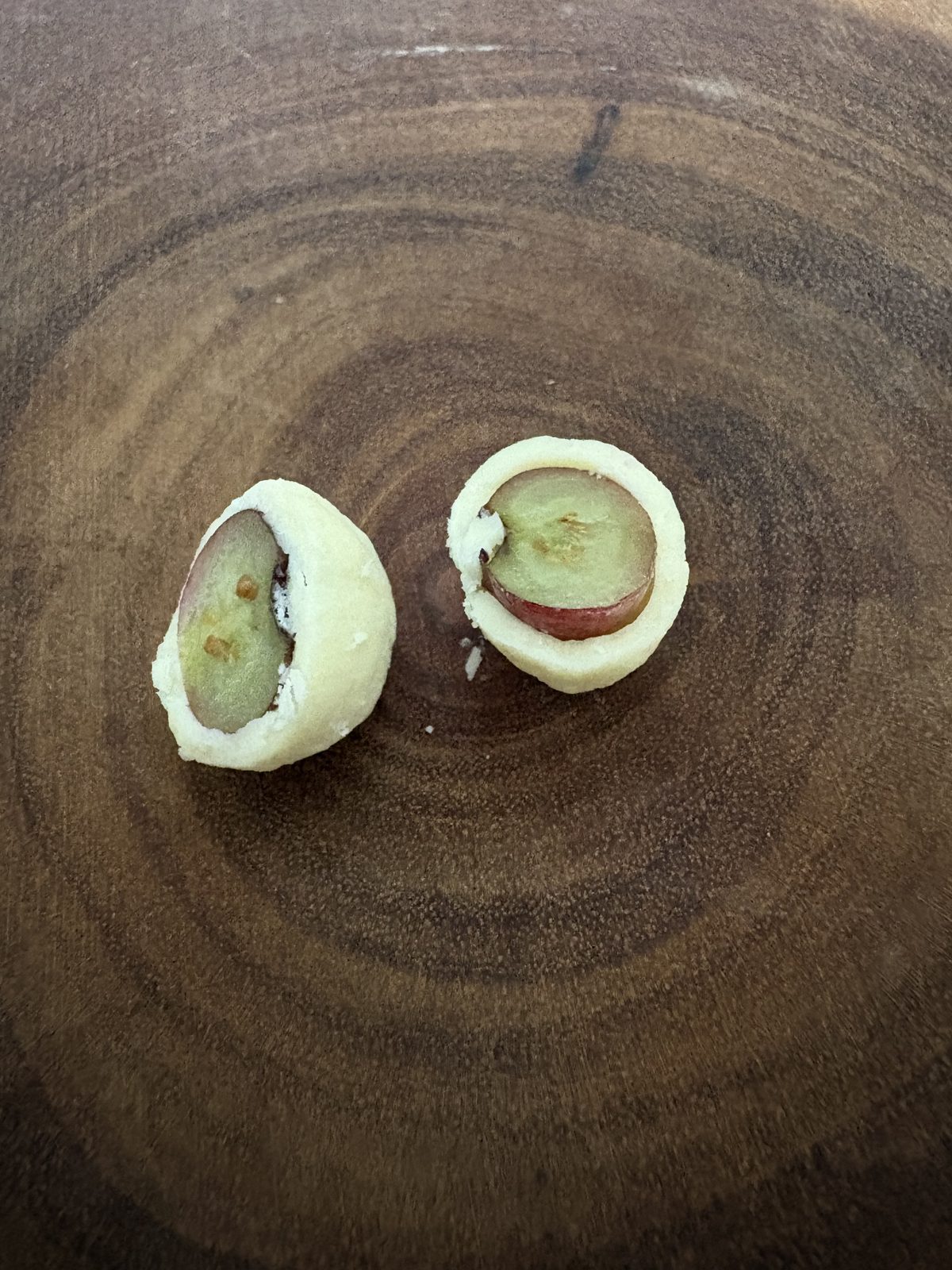 六花亭大地の滴を半分に割った断面アップ。ホワイトチョコの中に生のブルーベリーが丸ごと入っている