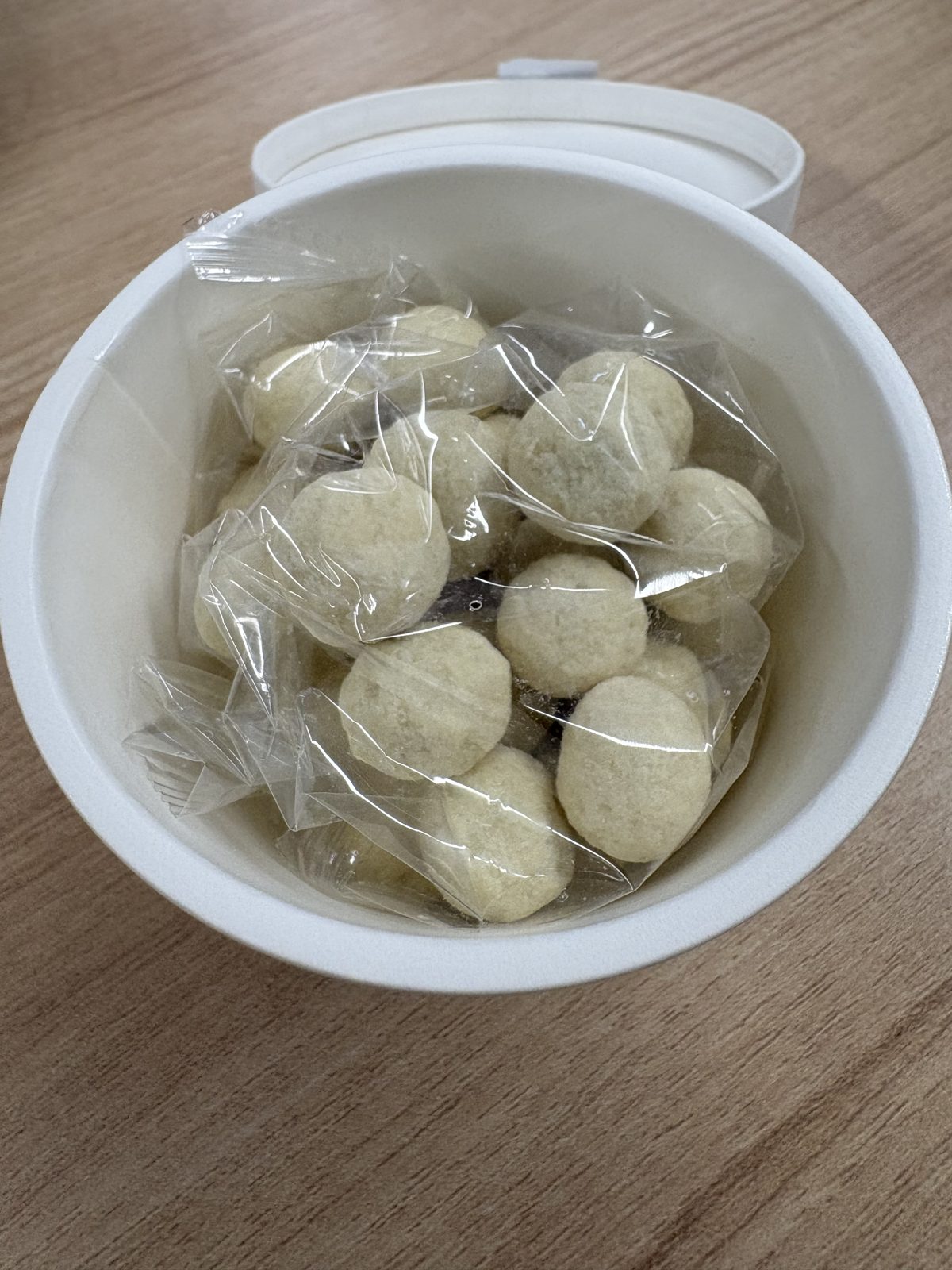六花亭大地の滴のカップを開けたところ。透明な袋にホワイトチョコでコーティングされたブルーベリーがたくさん入っている