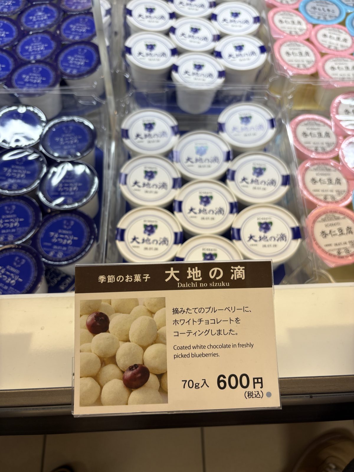 六花亭「大地の滴」の店頭POP。摘みたてのブルーベリーにホワイトチョコレートをコーティングしたと説明されている