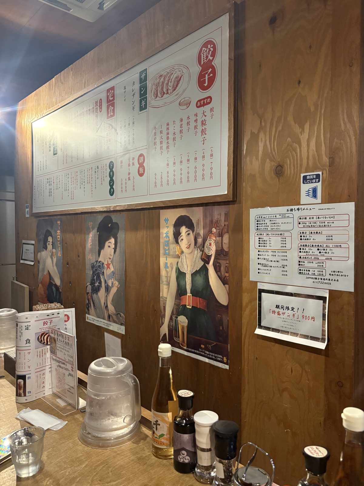SAPPORO餃子製造所の店内。レトロなポスターが並ぶ壁