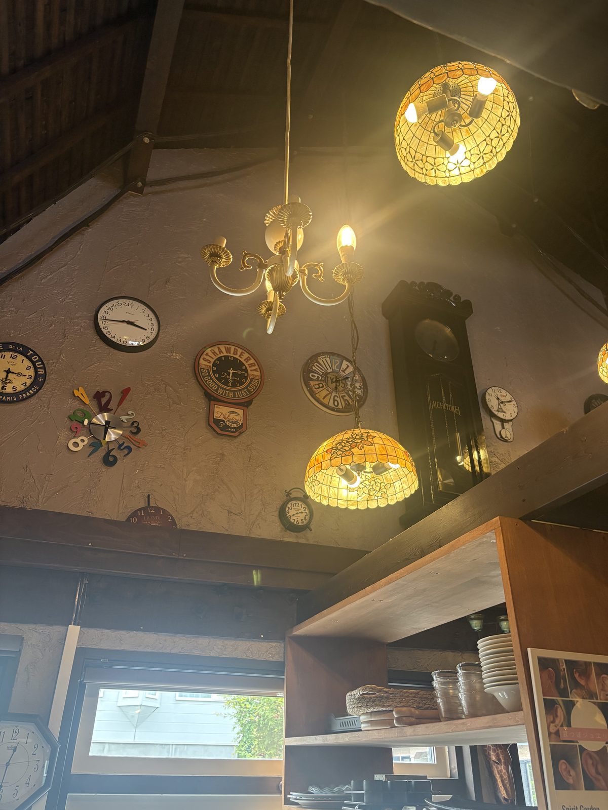 CAFE de JIKAN店内。高い天井とステンドグラス風のシャンデリア、壁の時計