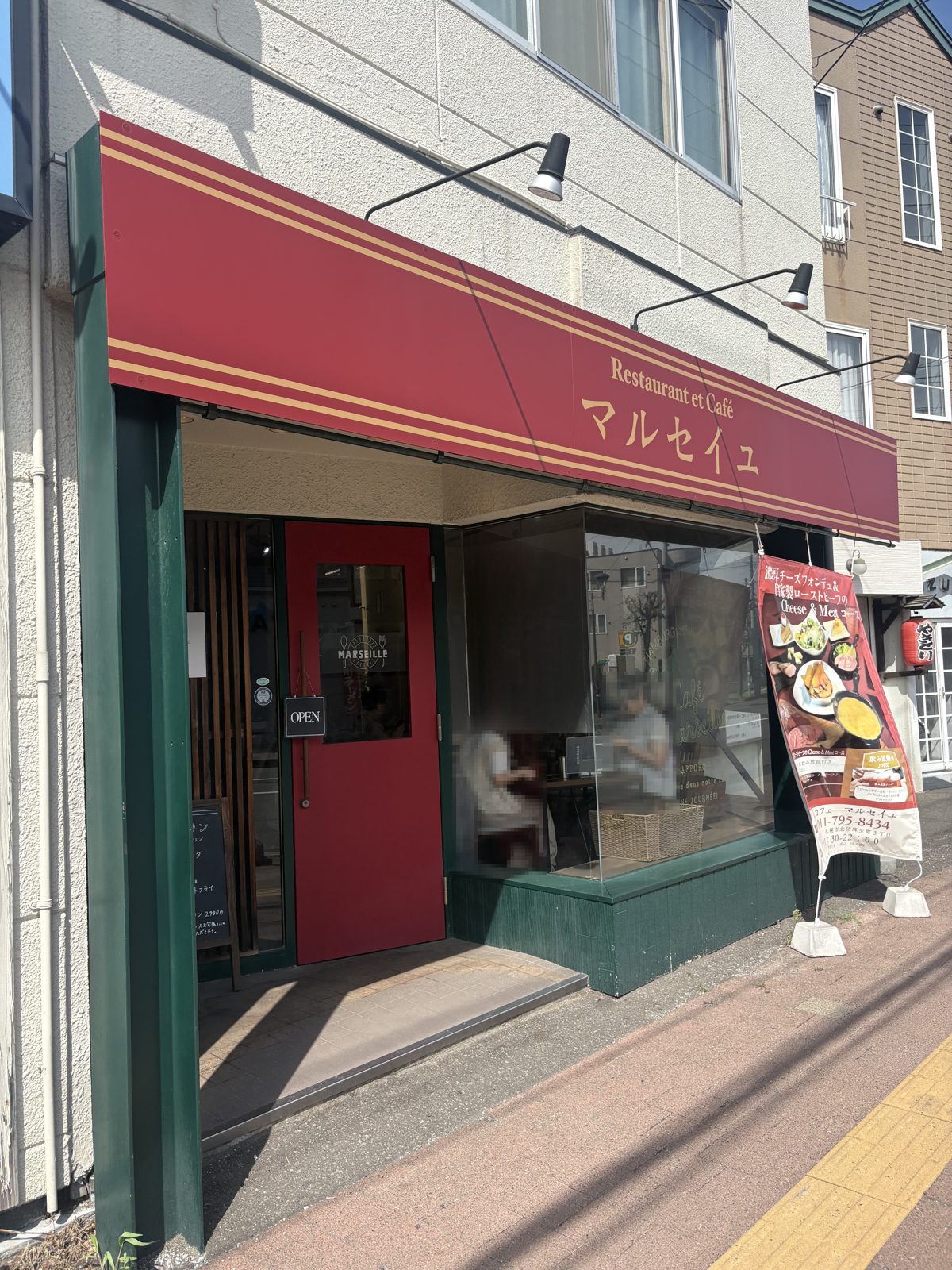 Café MARSEILLEの店舗外観。赤いオーニングにマルセイユと書かれている
