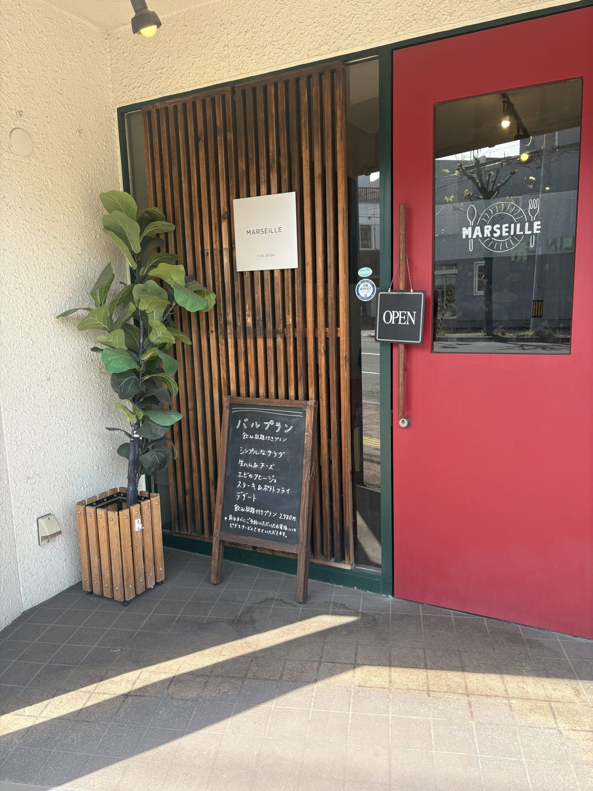 Café MARSEILLEの入口。赤い扉にOPENの札がかかっている