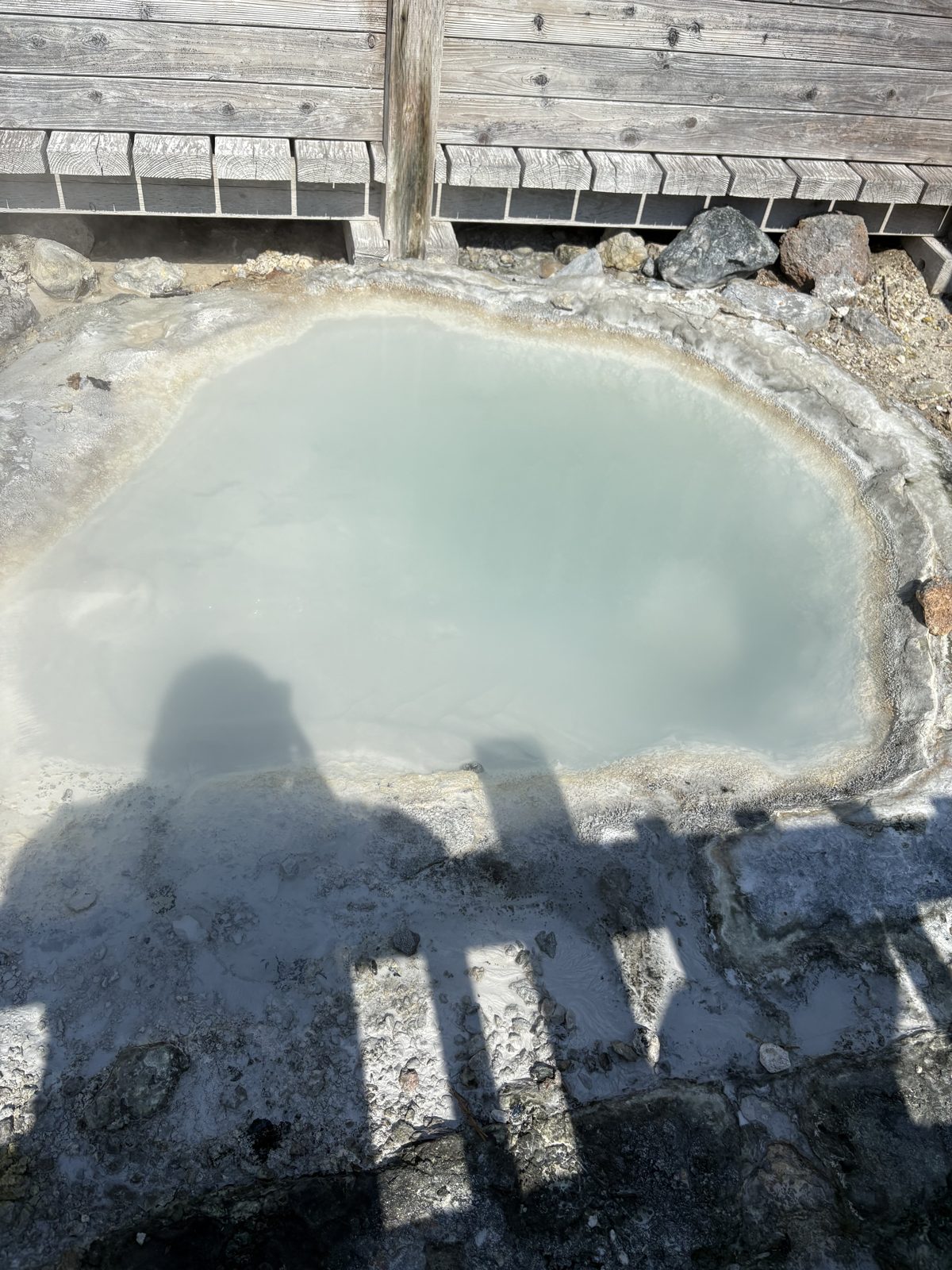 登別地獄谷の遊歩道から見える鉄泉池。乳白色の熱水がわく池