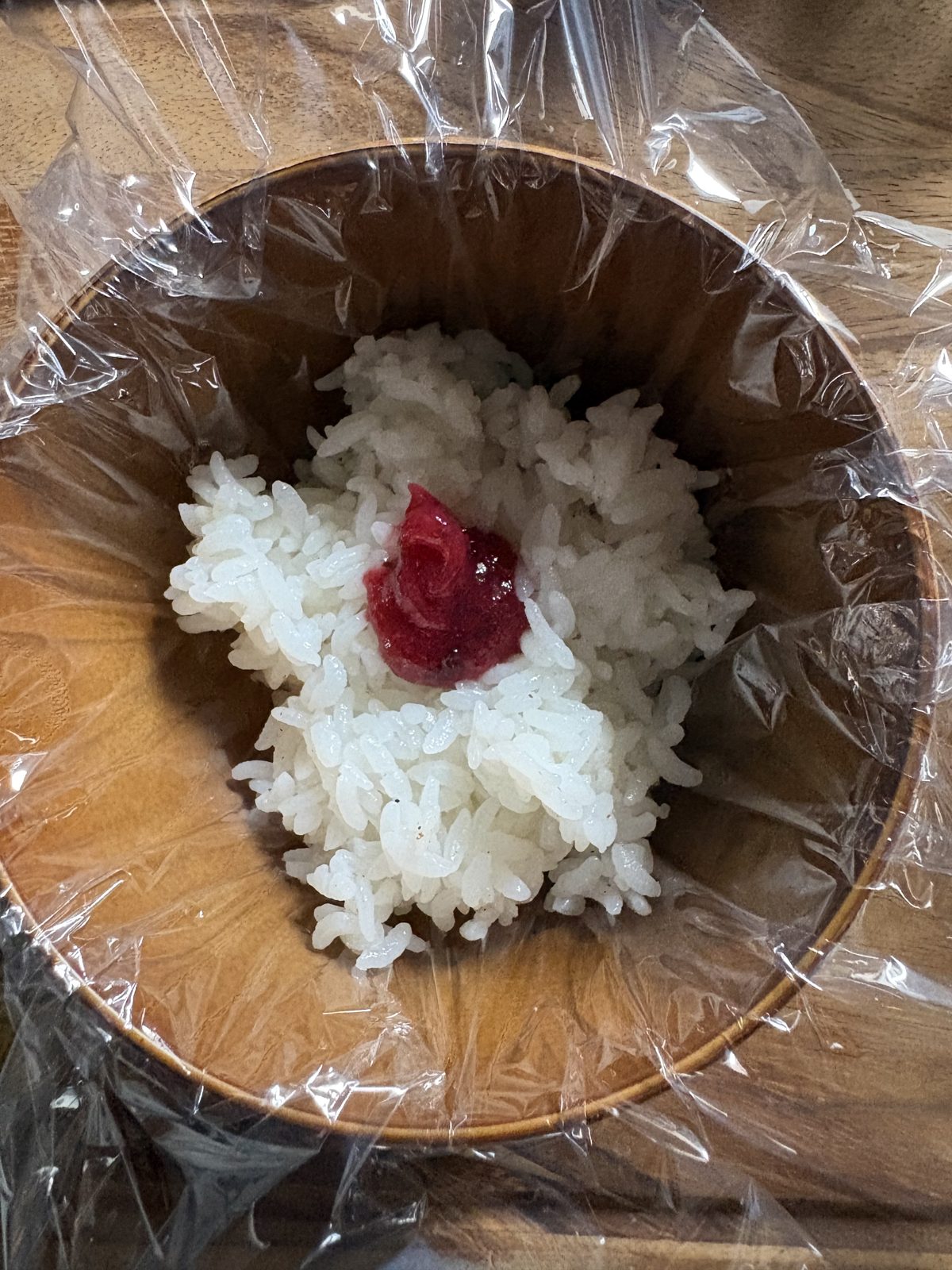 ラップを敷いた器のごはんの中央にねり梅をのせたところ