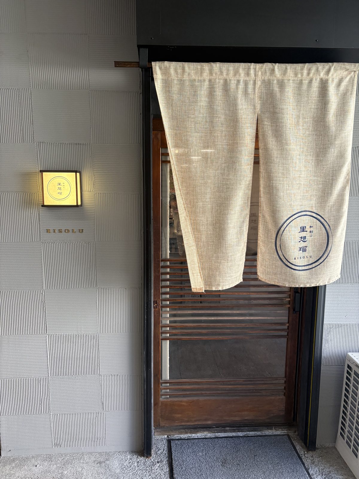 和創り里想瑠の入口。木の扉に暖簾がかかっている