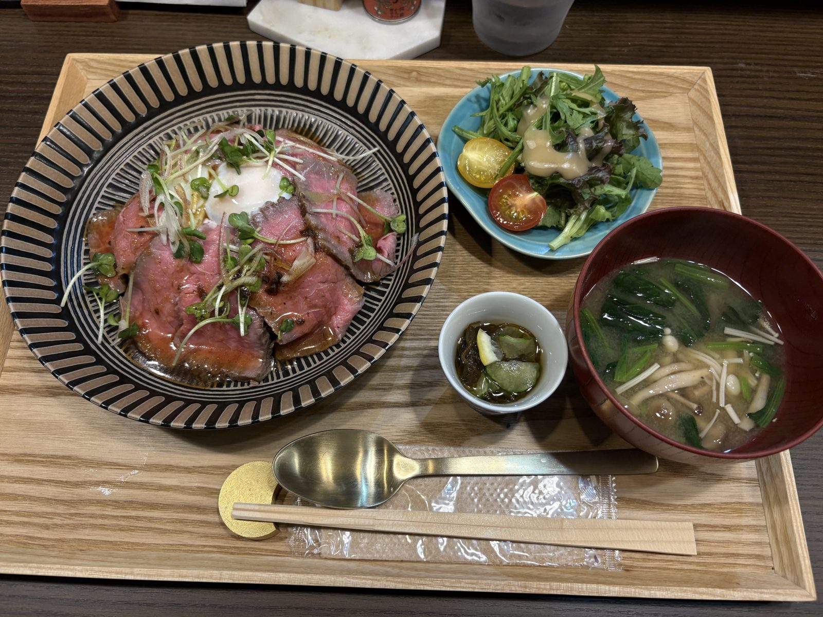 和創り里想瑠のローストビーフ丼定食一式。丼・サラダ・小鉢・味噌汁がお盆に並んでいる