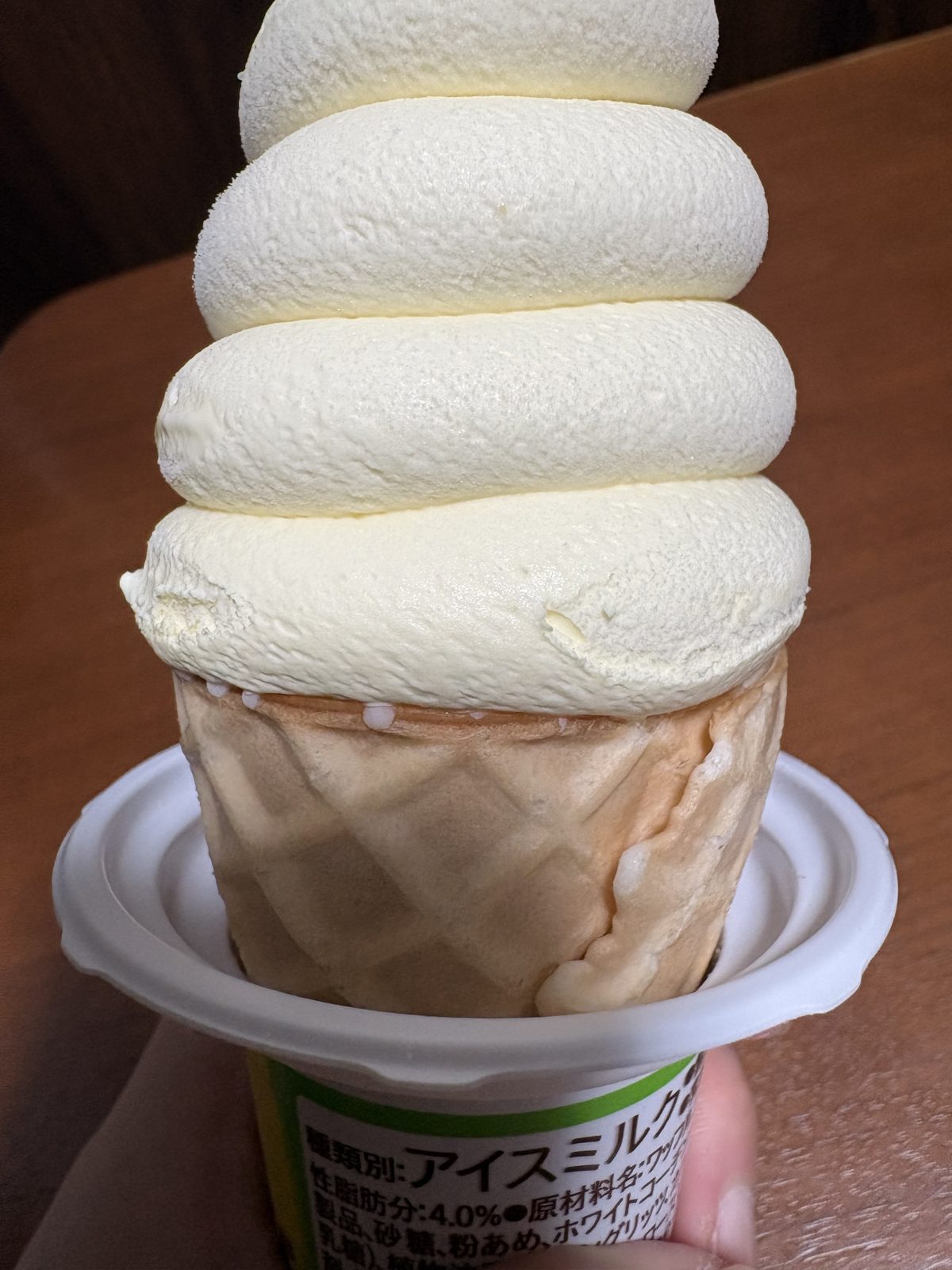 セイコーマートの北海道とうきびソフトをコーンに乗せた様子。クリーム色のなめらかな渦巻き