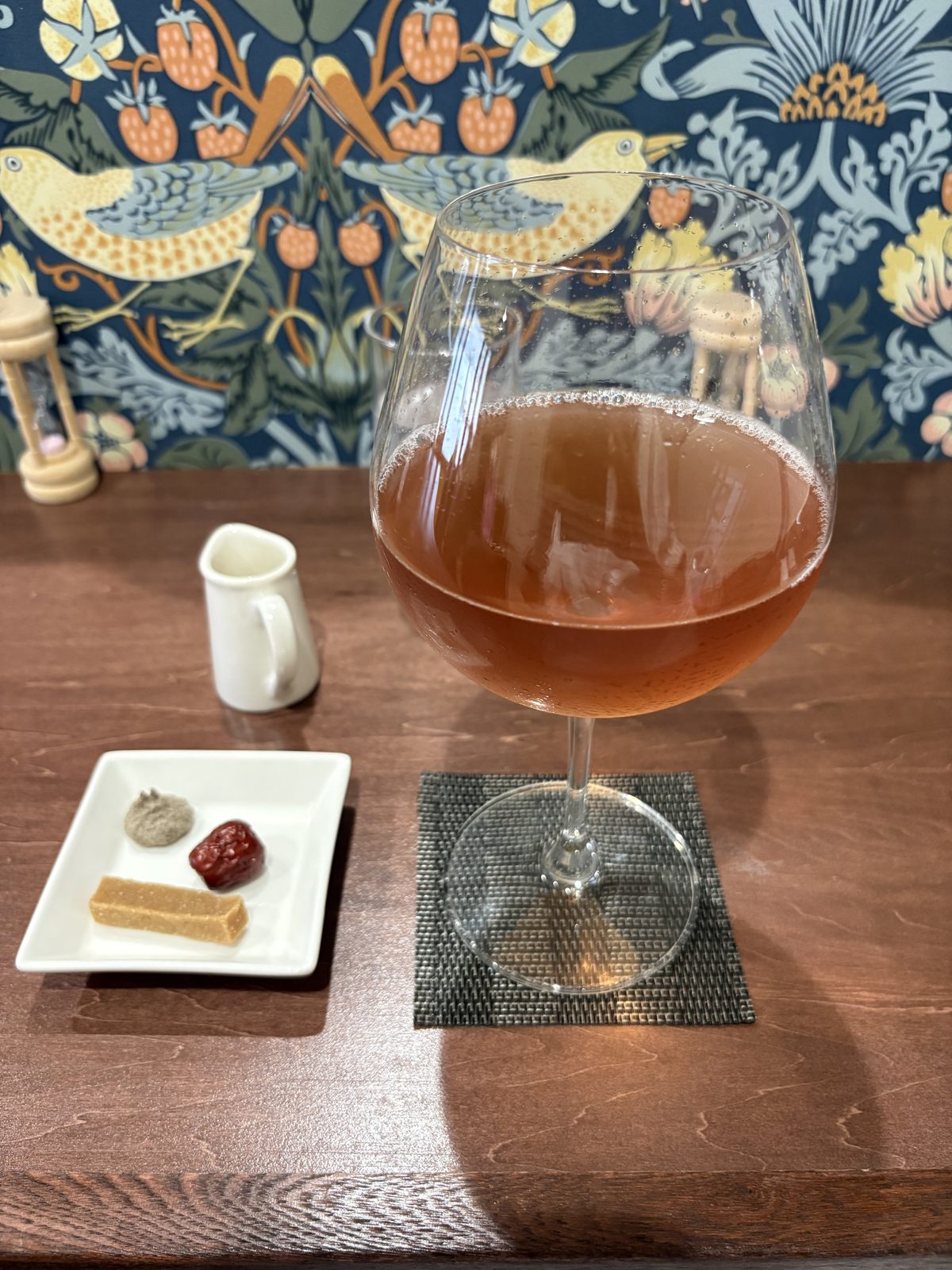 TEA TRIPのPurple Tea。ワイングラスに注がれたアイスティーとお茶請けの小皿
