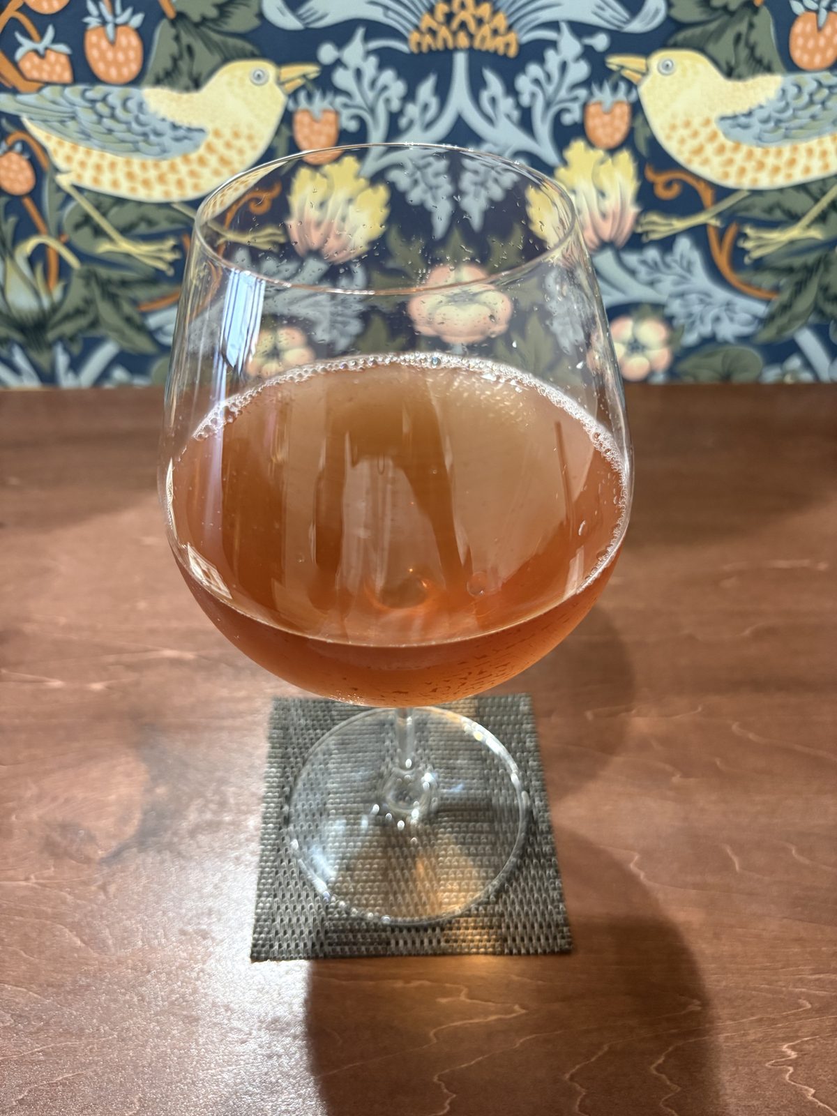ワイングラスに注がれたPurple Teaのアイスティー。琥珀色をしている
