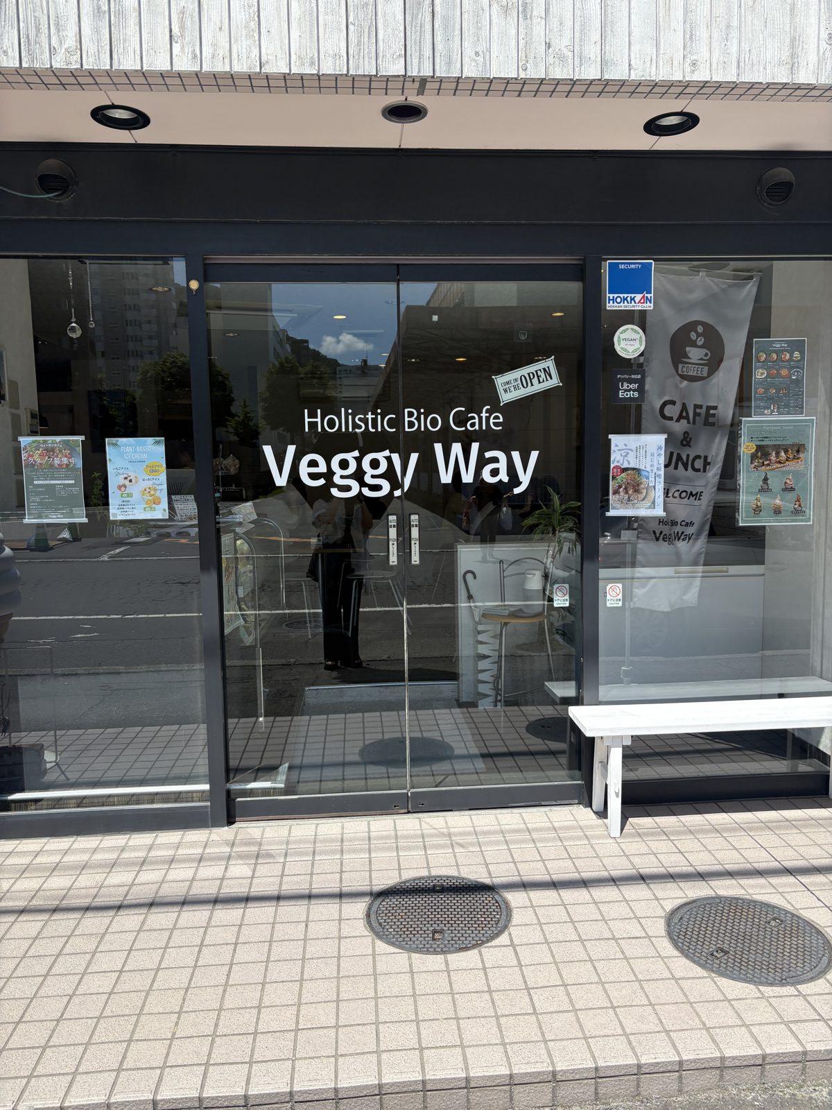Holistic Bio Cafe Veggy Wayの外観。黒い外壁に白い店名ロゴ
