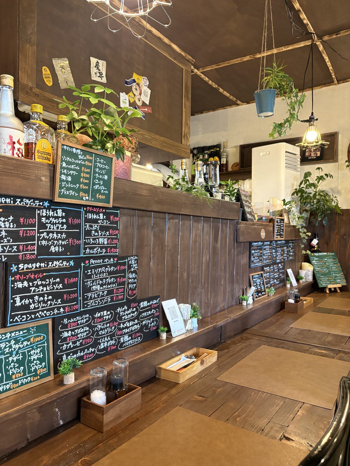Bar Ziioの店内カウンター。壁一面の黒板メニューと植物