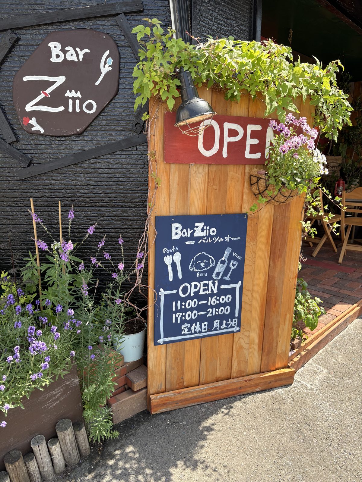 Bar Ziioの看板とOPENのボード。お花に囲まれた入口
